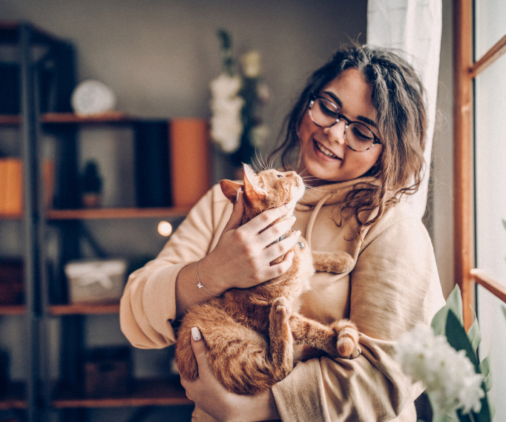 A ginger cat being held by a woman